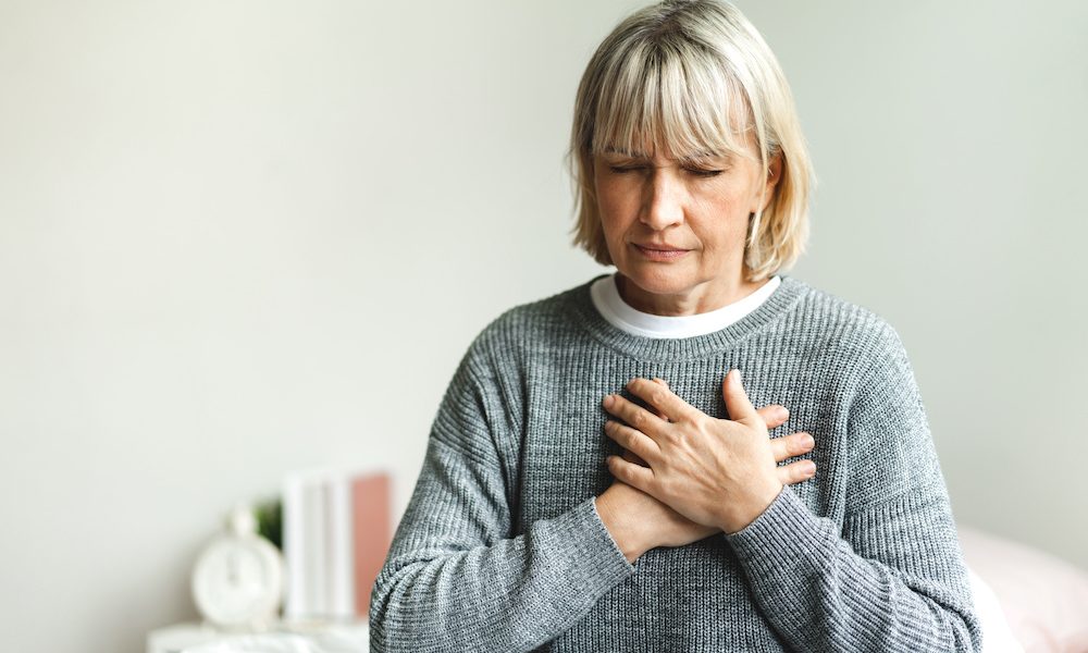 Senior adult elderly women sit on bed with chest pain suffering from heart attack in the bedroom.Healthcare and medical concept Women with heart issues on beta blockers face higher risk of death, study finds