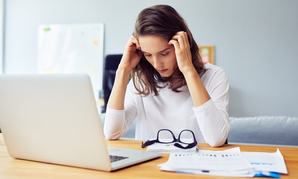 Stressed young woman sitting at desk working from home office Gender health gap has ‘profound impact’ on working women- report
