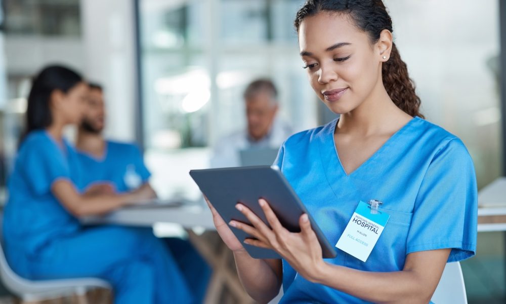 Hospital, doctor and woman on tablet for medical analysis, research and diagnosis report. Healthcare, clinic and happy female nurse on digital tech for wellness app, online consulting and service Comment: Democratisation without compromising care