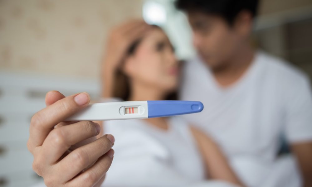 Sad parent complaining holding a pregnancy test sitting on bed Can biotech help close the fertility gap? Inside the race to improve egg quality