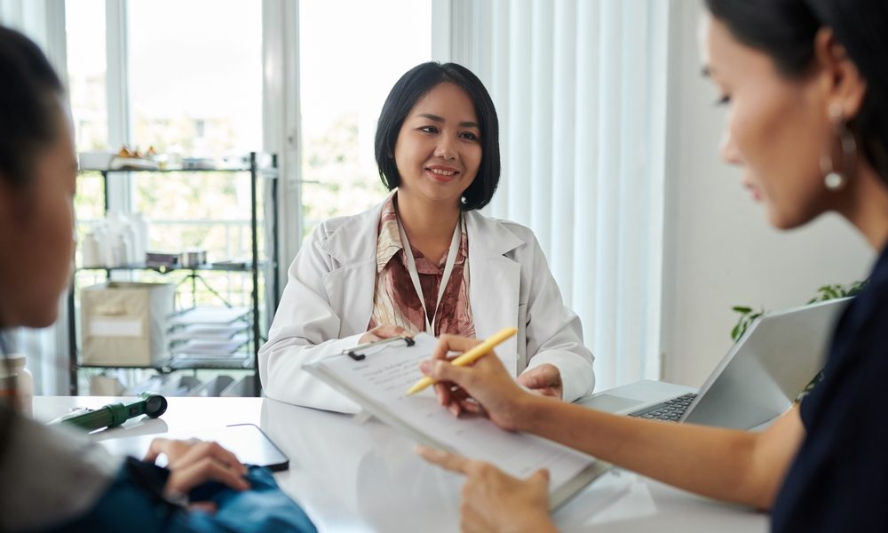 Smiling pediatrician asking mother of patient to fill form with medical history Women’s health network secures investment