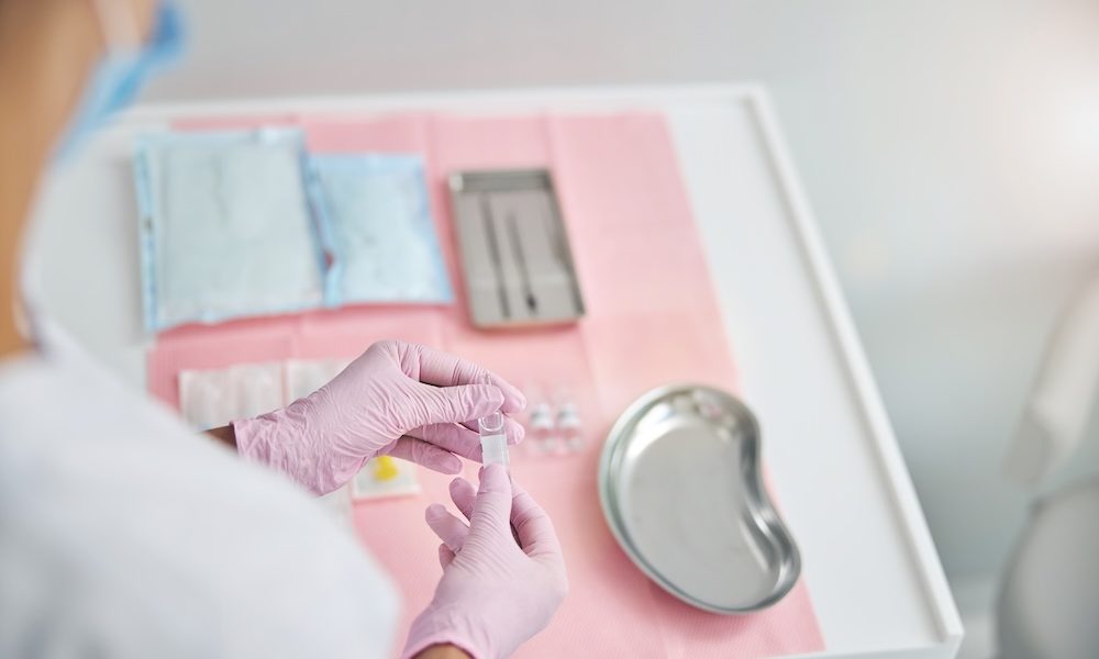 Certified dermatologist examining an ampule with liquid Open science advances non-hormonal contraceptives