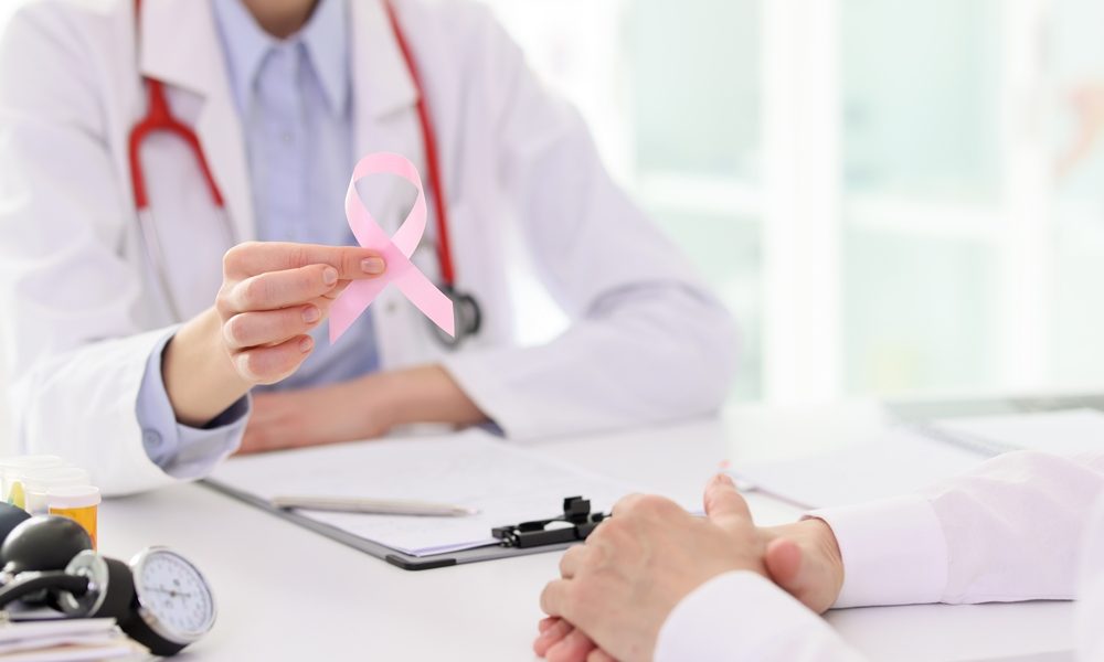 Doctor holds pink ribbon at appointment with patient AstraZeneca drug approved for breast cancer in EU