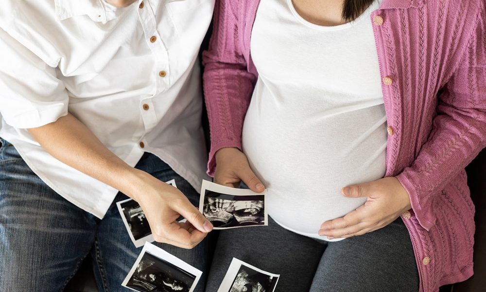 Happy pregnant couple of husband and wife. New pregnancy treatment shows promise for at-risk twins