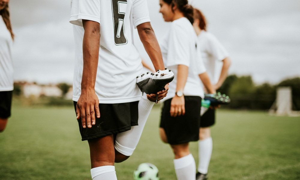 Female soccer team players stretching pre game Chelsea FC Women to launch first-of-its-kind player fertility fund